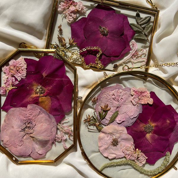 Brass hanging flower frame displaying pink-themed preserved blooms, handcrafted by Happihome for timeless floral wall décor.