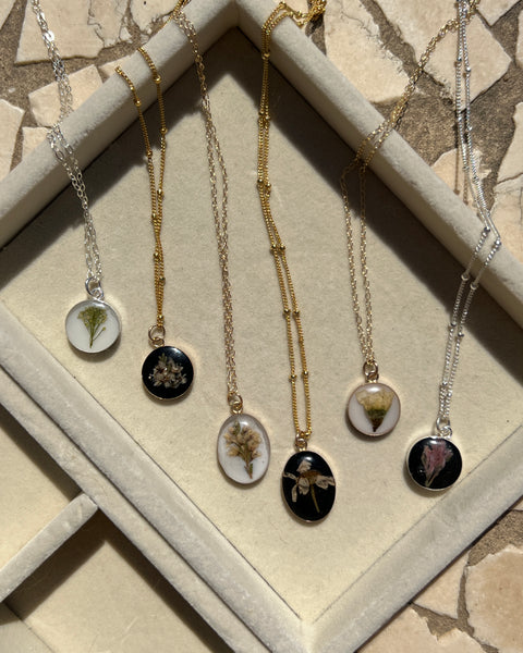Sterling silver pendant necklace in round and oval shapes featuring preserved flowers, handcrafted by Happihome as a delicate floral keepsake.